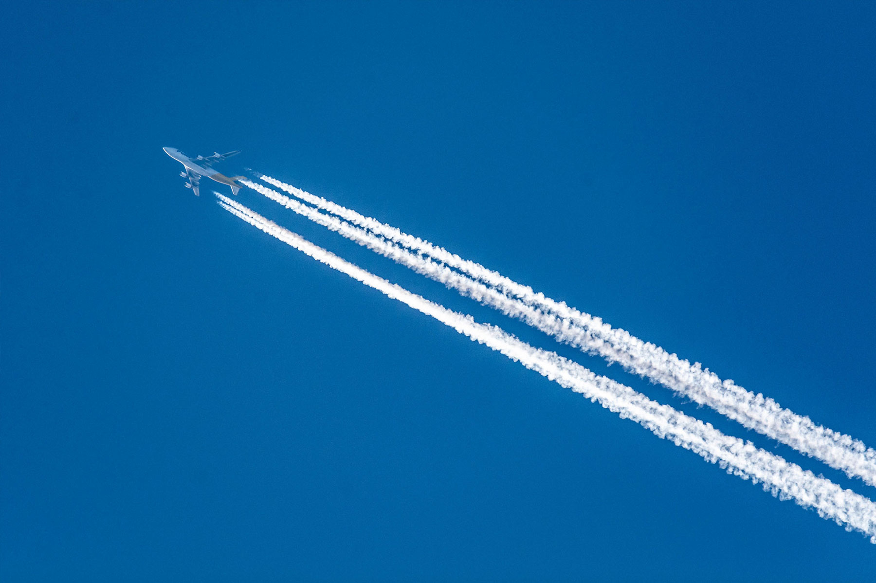 Plane takeoff and clouds in a deep blue sky