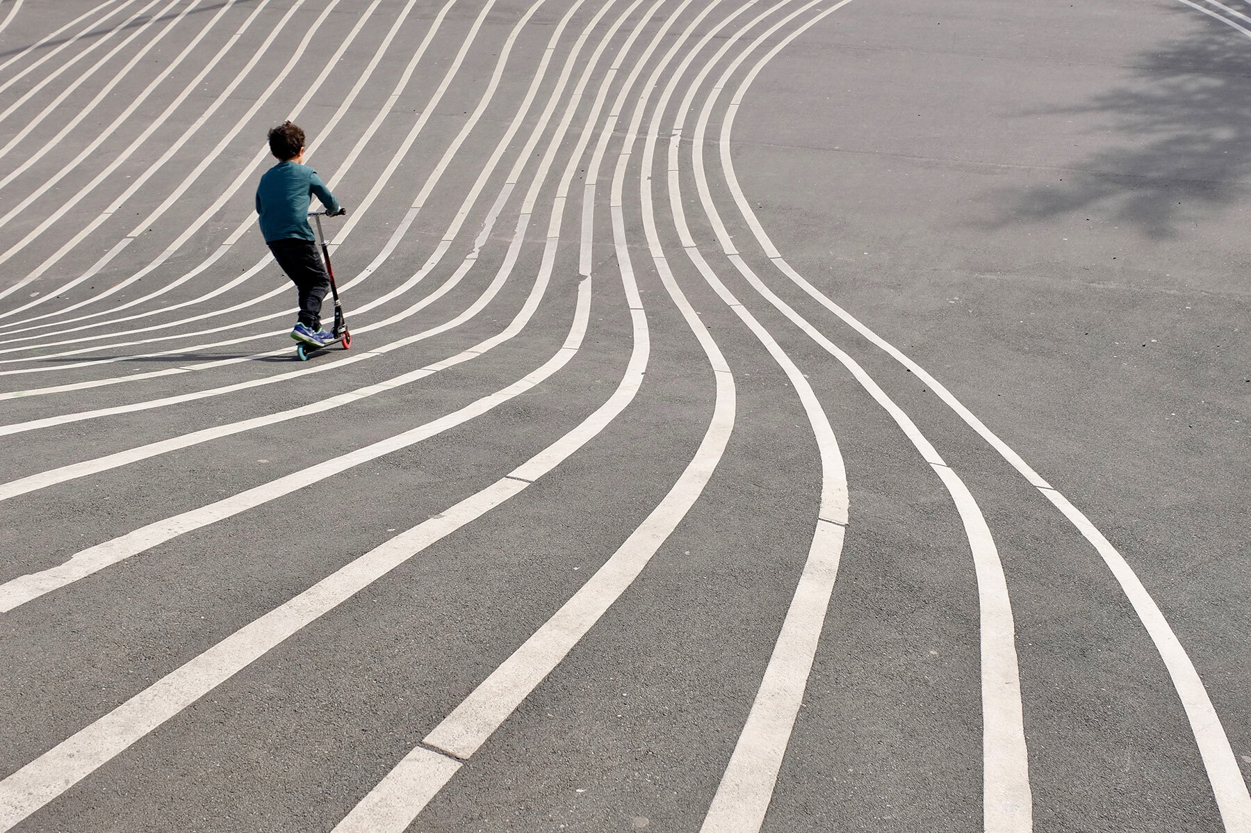 boy playing skateboard on gray concrete pavement