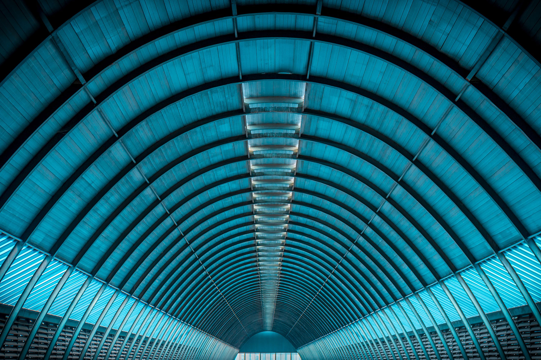inside a tunnel with symmetrical rafters blue tones